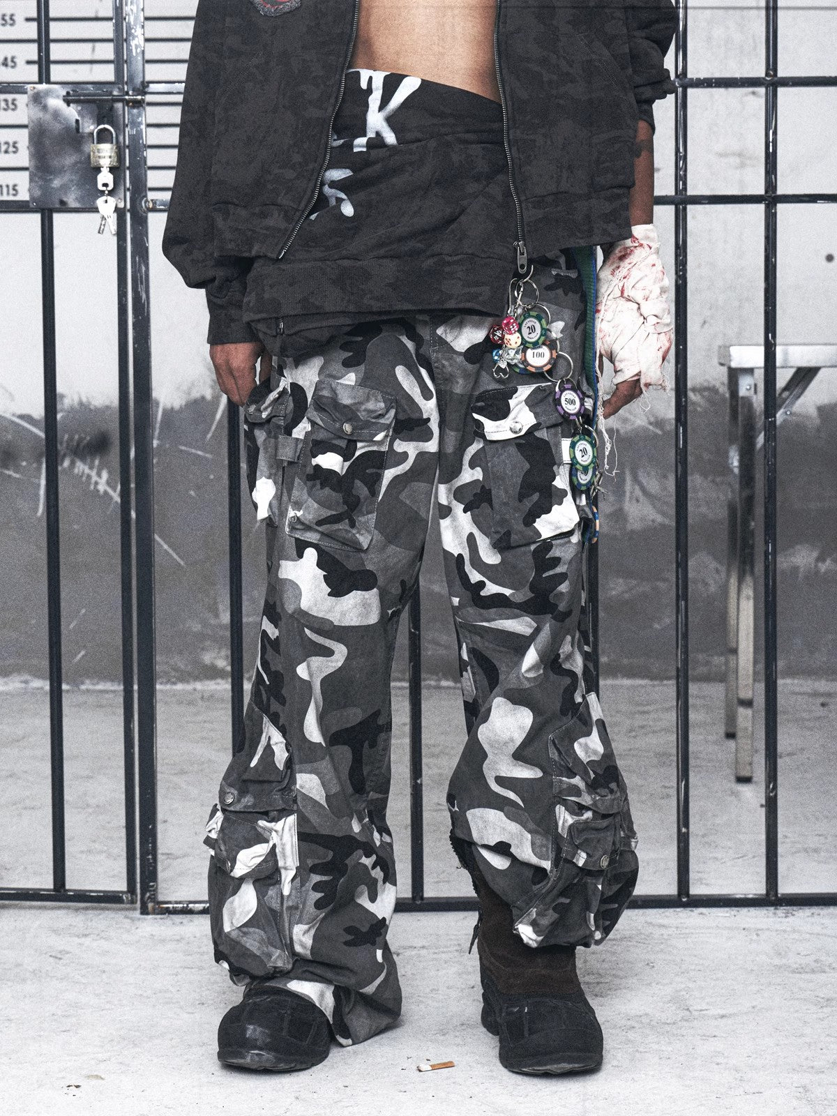 ヴィンテージウォッシュ加工とダメージ加工を施したマルチポケット刺繍入りグレールーズ迷彩パンツ