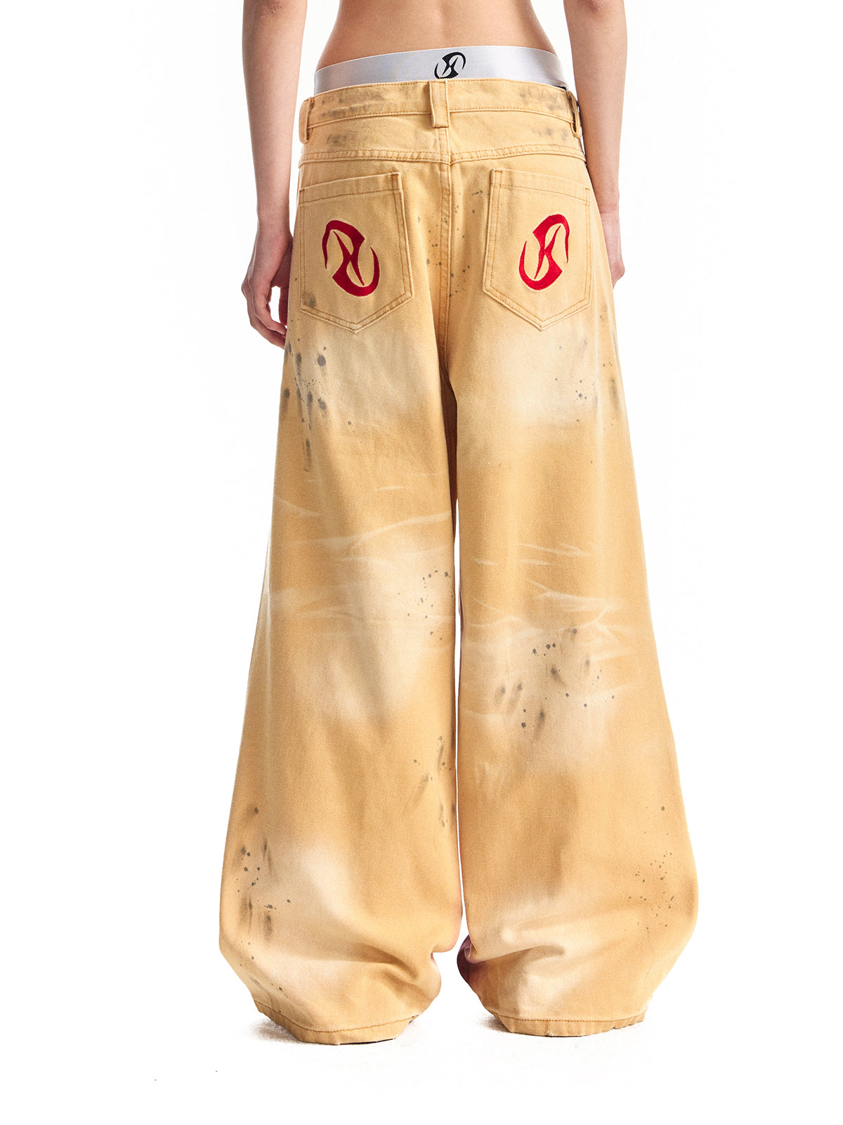 色あせたゆるいだぶだぶのシルエットのスプレー コード リューがインクをはねて古い黄色のパンツを作りました。